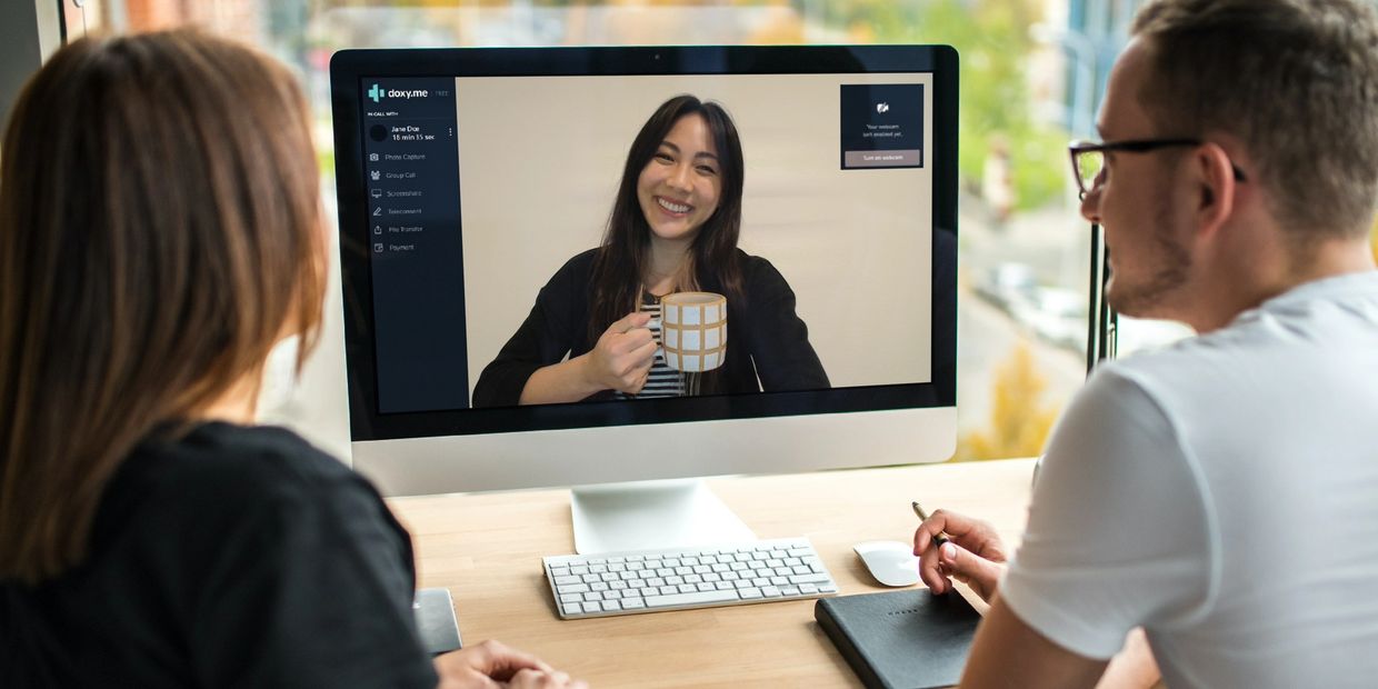 Man & woman in front of a iMac monitor joining a virtual video call with AAPI therapist Lan Nguyen