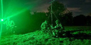 Soldiers operating with green night vision.