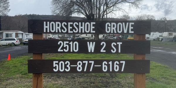 Sign for Horseshoe Grove with address and phone number.