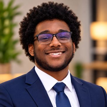 Young man smiling in a suit and tie.