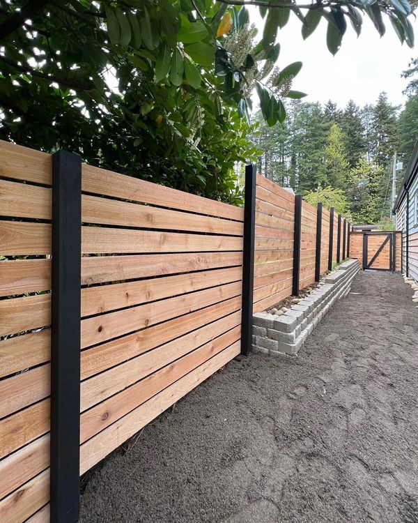 Small retaining wall and fence with black metal accent