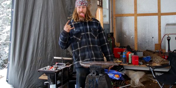 shop owner standing next to the anvil and forge