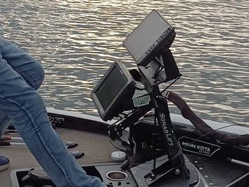 Person setting up fish finders on a boat.