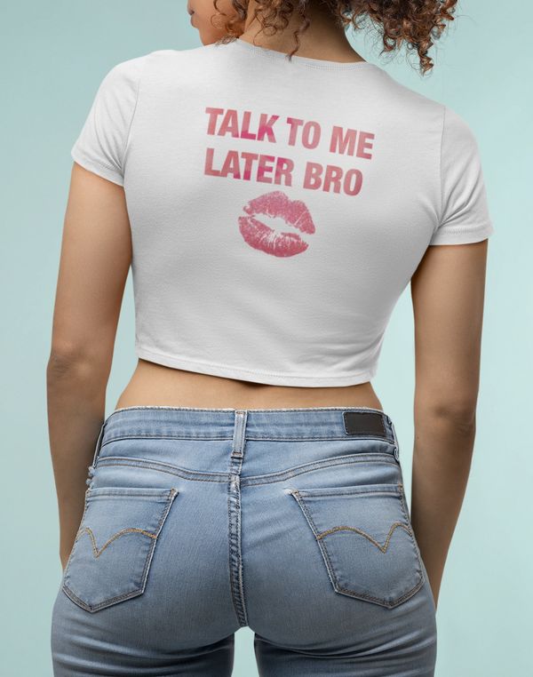 Woman wearing a white cropped t-shirt with 'Talk to me later bro' printed on the back.