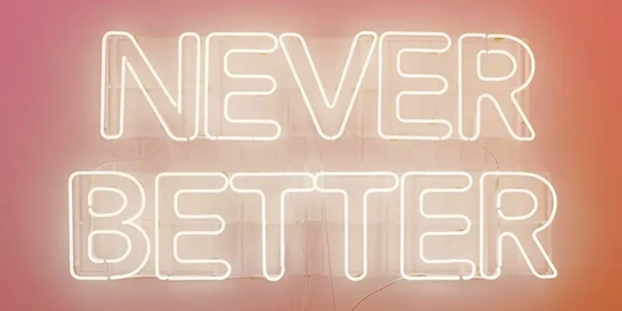 Neon sign displaying the words 'NEVER BETTER' against a warm gradient background.