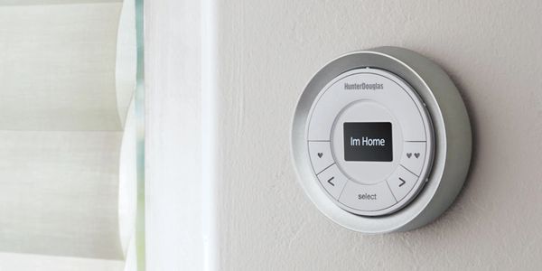 Modern smart thermostat on a wall displaying 'I'm Home'.