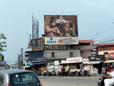Busy street corner with billboard advertisement and traffic.