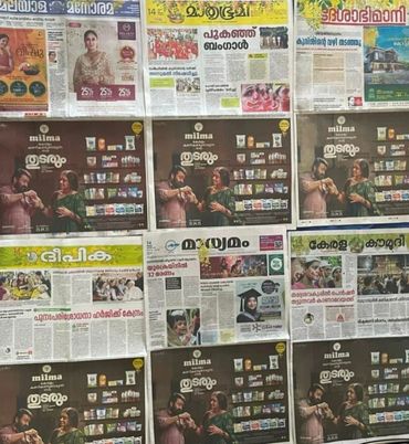 Newspapers with a Milma advertisement showing people enjoying dairy products.