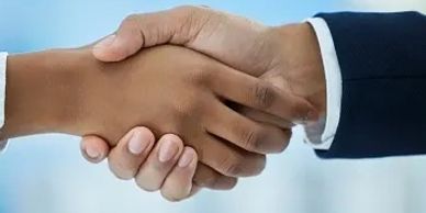 Two people shaking hands, symbolizing agreement or partnership.