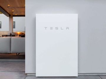 Batería Tesla Powerwall blanca junto a una pared.