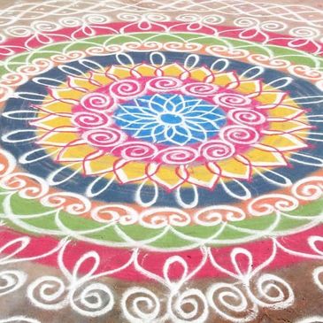 Colorful, intricate rangoli design with floral and spiral patterns.