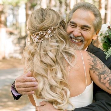 A joyful embrace between a bride and an older man.