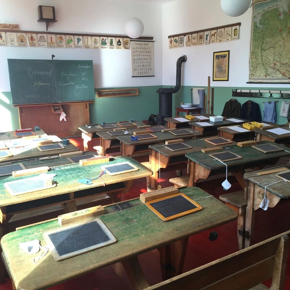 Old style classroom with desks with slates.