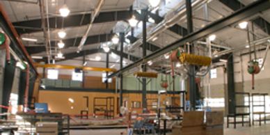 Inside view of an industrial warehouse with overhead cranes and metal structures.