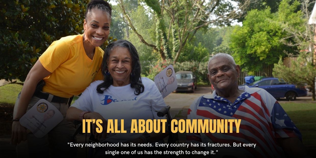 Three people smiling outdoors with community-themed text.