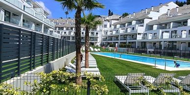 Modern apartments with a pool and greenery.