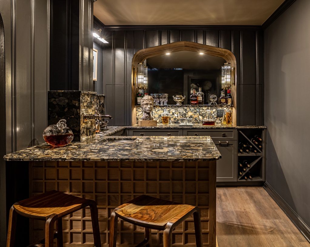 Elegant home bar with marble countertop and wooden stools.