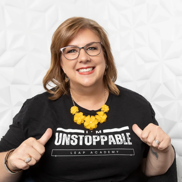 The mentor, Heather, using her thumbs to point to her black & white shirt that she is unstoppable.