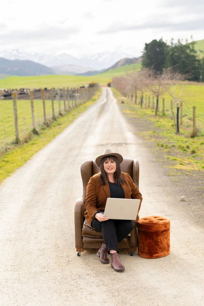 Michelle sitting on her driveway on a chair with her laptop