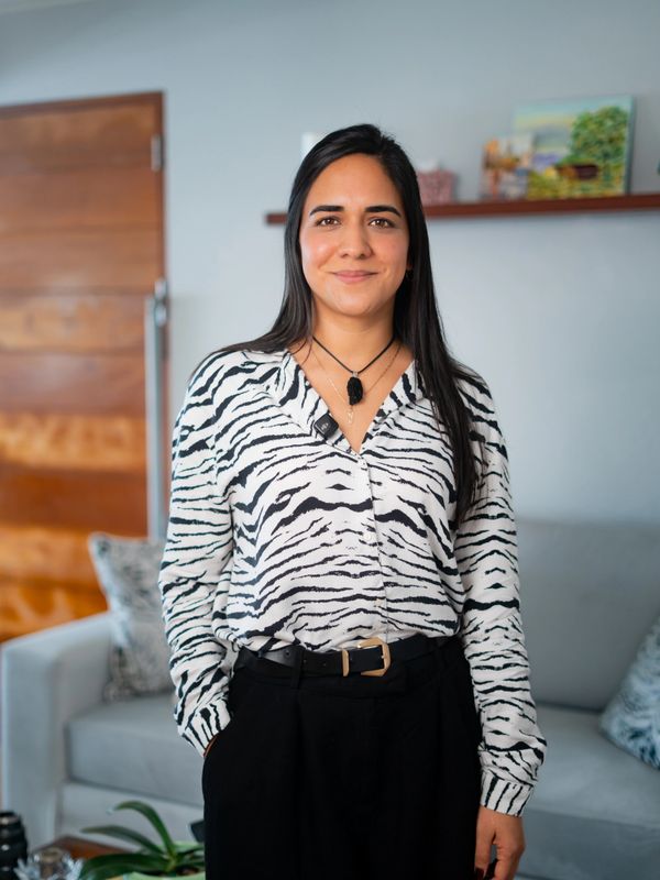 Woman wearing a black and white zebra print shirt standing indoors.