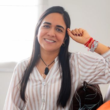 Smiling woman with long hair in striped shirt relaxing indoors.