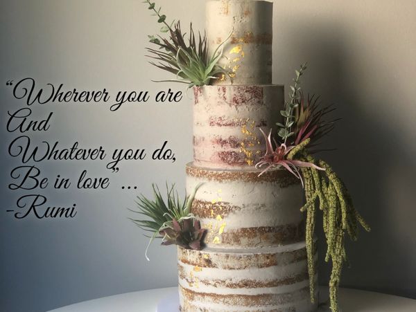 Rustic four-tiered cake decorated with greenery and gold accents beside a Rumi love quote.
