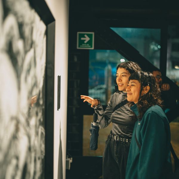 Two women admiring artwork in a gallery.