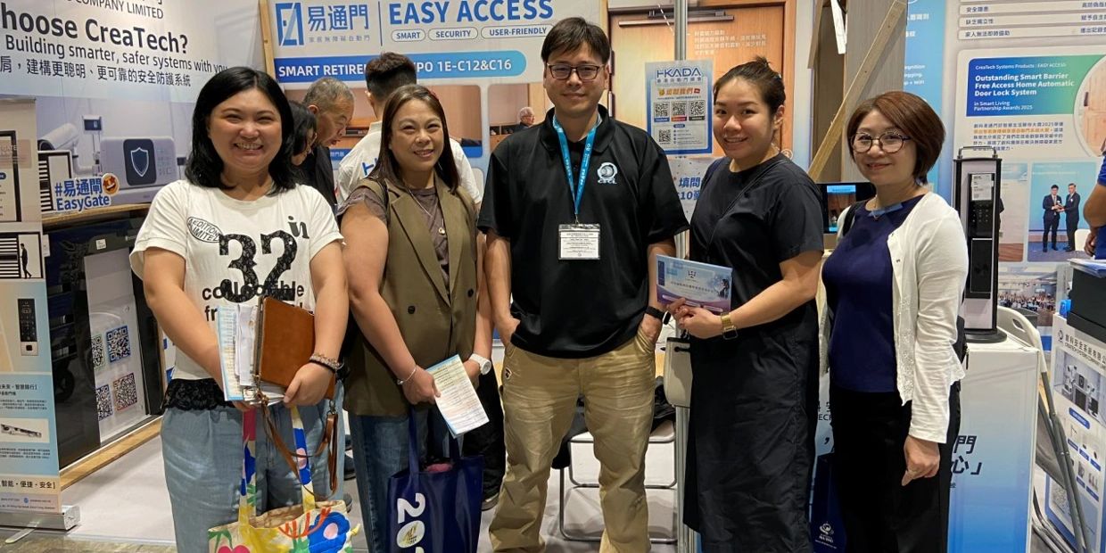 Five people smiling at a tech expo booth promoting easy access systems.