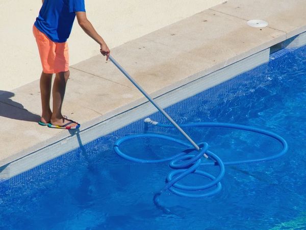 Person cleaning swimming pool