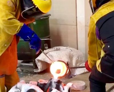 bronze being poured into moulds from a hot crucible