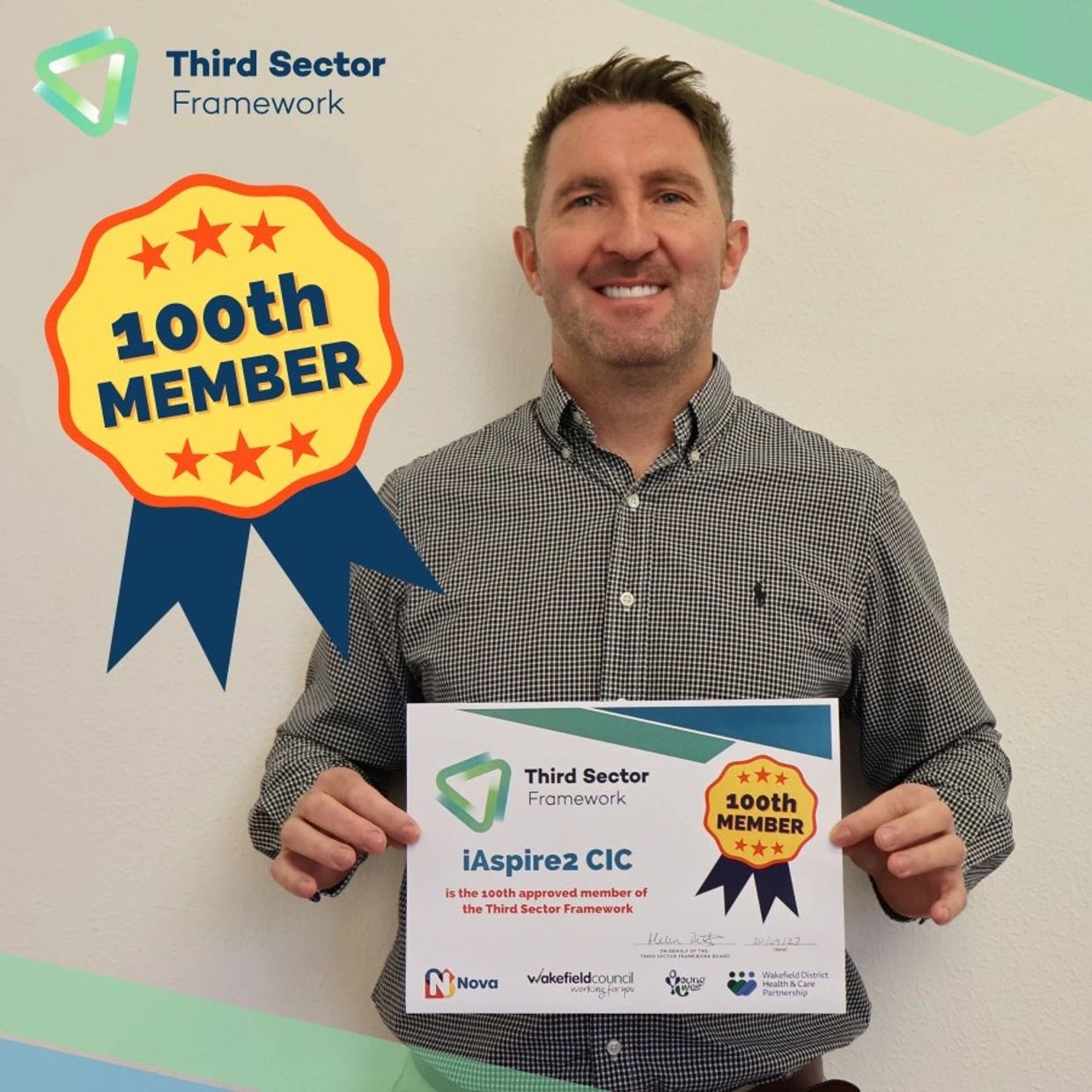 Man holding a certificate celebrating iAspire2 CIC as the 100th member of Third Sector Framework.