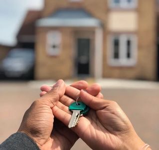 A couple holding a house key in their hands.