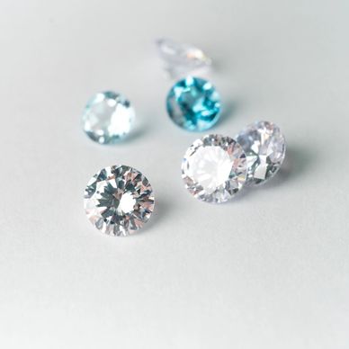Close-up of round, faceted gemstones on a light surface.
