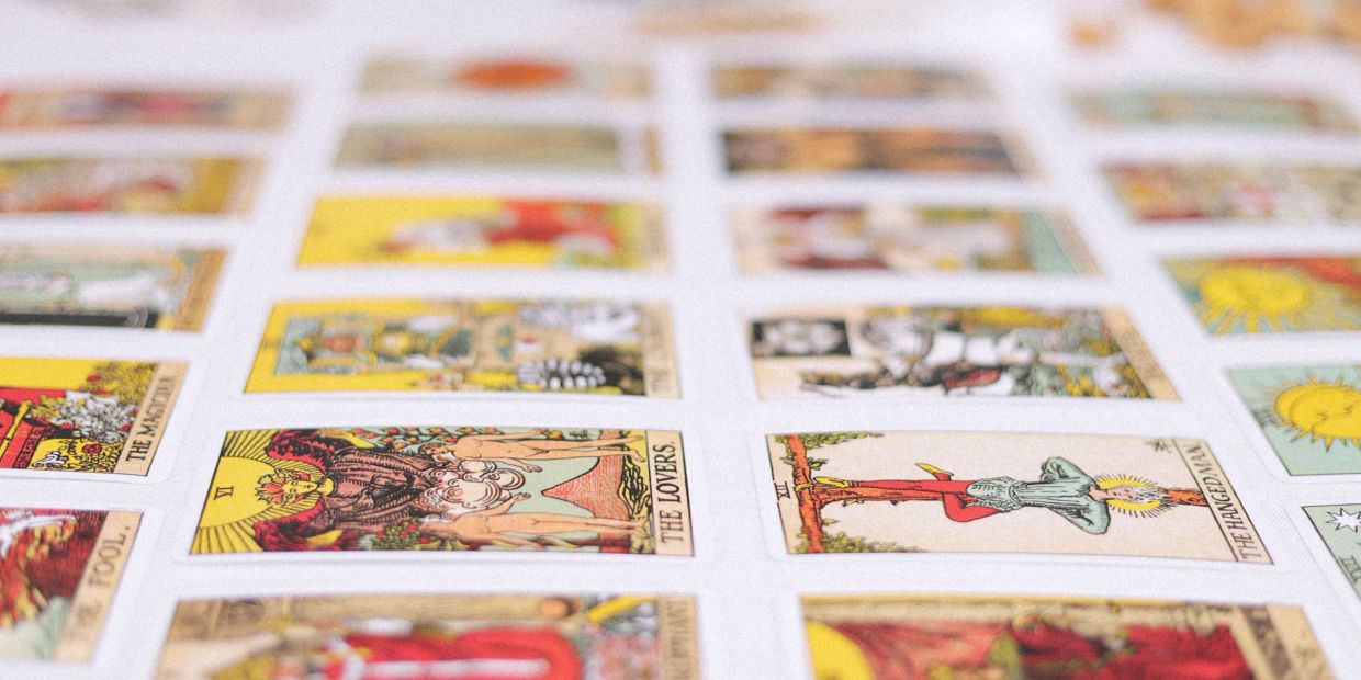 Rows of colorful tarot cards laid out on a white surface.