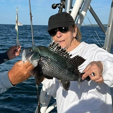 Man holding a large spiky fish on a boat.