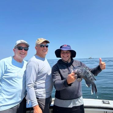 Three people on a boat with a fish.