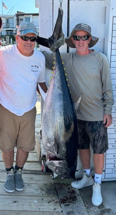 Two men posing with a large caught fish.