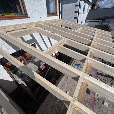 Wooden framework for a roof extension on a residential building.