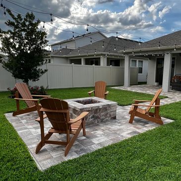 Flagstone pavers around a custom block fire pit with a walkway connecting to the rear lanai. 