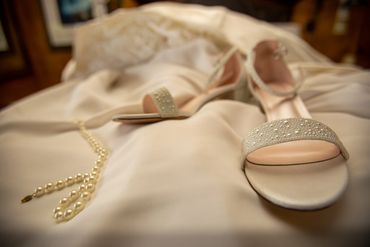 Wedding Accessories Shoes and Pearls draped over the dress 
