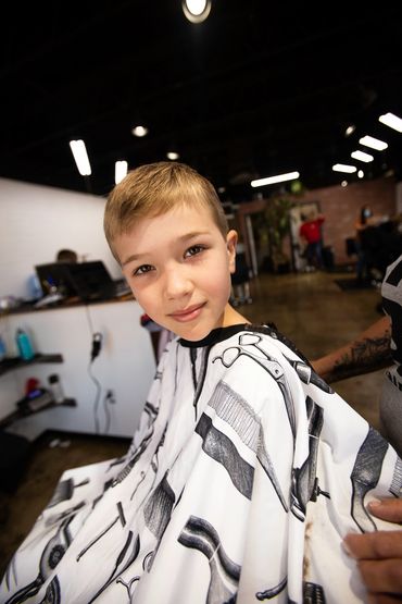 Kid getting a Haircut at Bj's Hair Shop