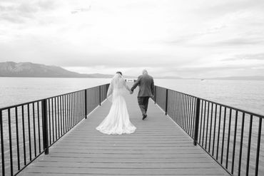 Newlyweds walk down a pier in South Lake Tahoe, California 