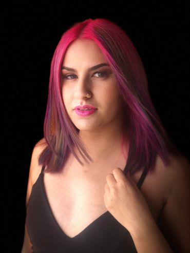 A woman red colour apply on the hair and looking ahead
