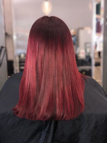 A woman apply red colour on the hair
