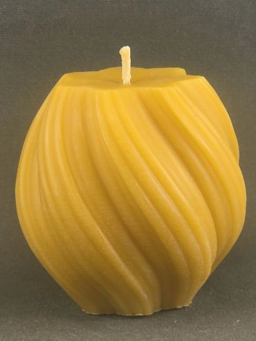 Yellow sculpted candle with a twisted design.
