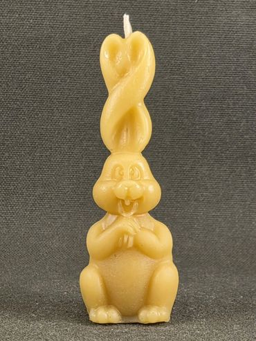 A bunny-shaped candle with twisted ears, smiling cheerfully.
