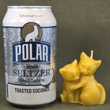 Can of Polar Seltzer Toasted Coconut next to a yellow cat-shaped candle.
