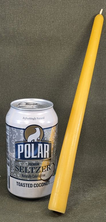 A can of Polar toasted coconut seltzer with a tall yellow candle.