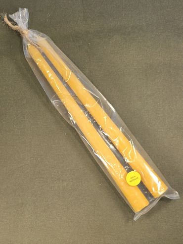 Pair of yellow taper candles in plastic packaging with a small yellow label.