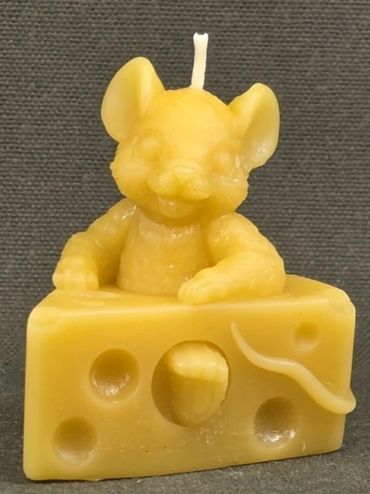 Yellow candle shaped like a mouse in a cheese wedge.